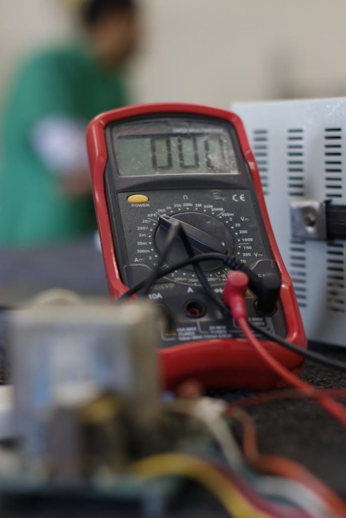 Close-up shot of a multimeter used for electrical measurements, with focus on the display.